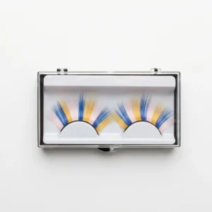 Estuche transparente con un par de pestañas postizas de colores vibrantes en tonos azul, amarillo y rosa pastel sobre fondo blanco.