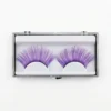 Pestañas postizas moradas de fantasía con glitter en estuche transparente sobre fondo blanco profesional.