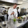 Chef profesional utilizando la batidora de inmersión de 1000W para preparar salsas y purés en una cocina industrial.