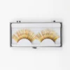Caja de pestañas postizas de oropel dorado con brillo multicolor en estuche transparente protector para almacenamiento.