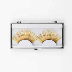 Caja de pestañas postizas de oropel dorado con brillo multicolor en estuche transparente protector para almacenamiento.