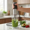 Batidora de mano potente preparando un smoothie verde con aguacate y espinacas en un vaso medidor.