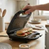 Detalle de sándwich caliente con vapor y marcas de grill crujientes recién hecho en la prensadora de panini profesional.