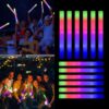 Jóvenes usando Palos de Espuma LED Mega Espuma 50 Jóvenes bailando con palos de espuma LED Mega Espuma 50 encendidos en colores neón durante una fiesta