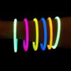 Mano con pulseras luminosas Glow Elite encendidas mostrando colores brillantes en ambiente nocturno