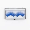 Un par de pestañas postizas tupidas de color azul eléctrico presentadas en un estuche transparente con base blanca sobre fondo blanco