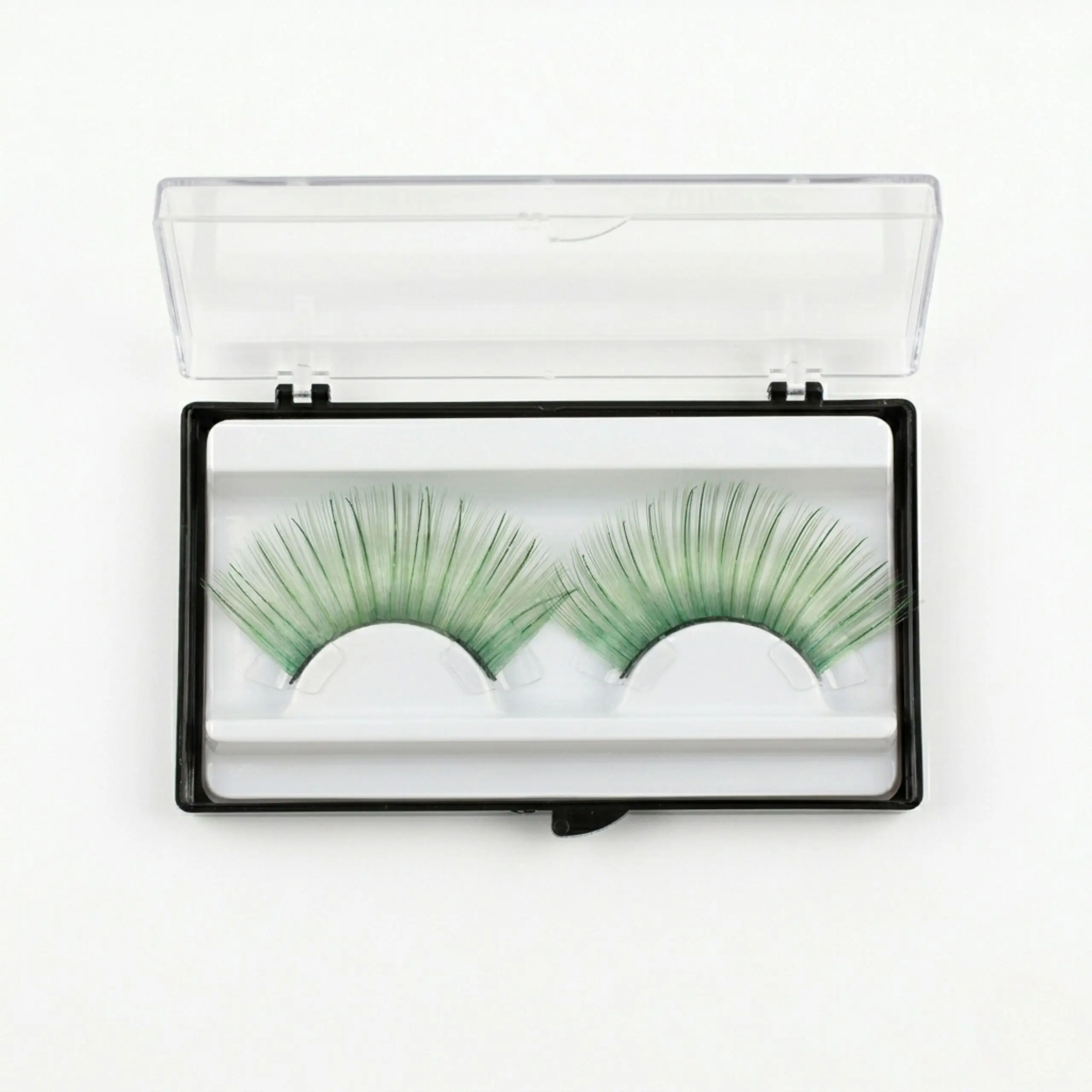Par de pestañas postizas verde esmeralda reutilizables en su caja de almacenamiento transparente para maquillaje de fantasía.