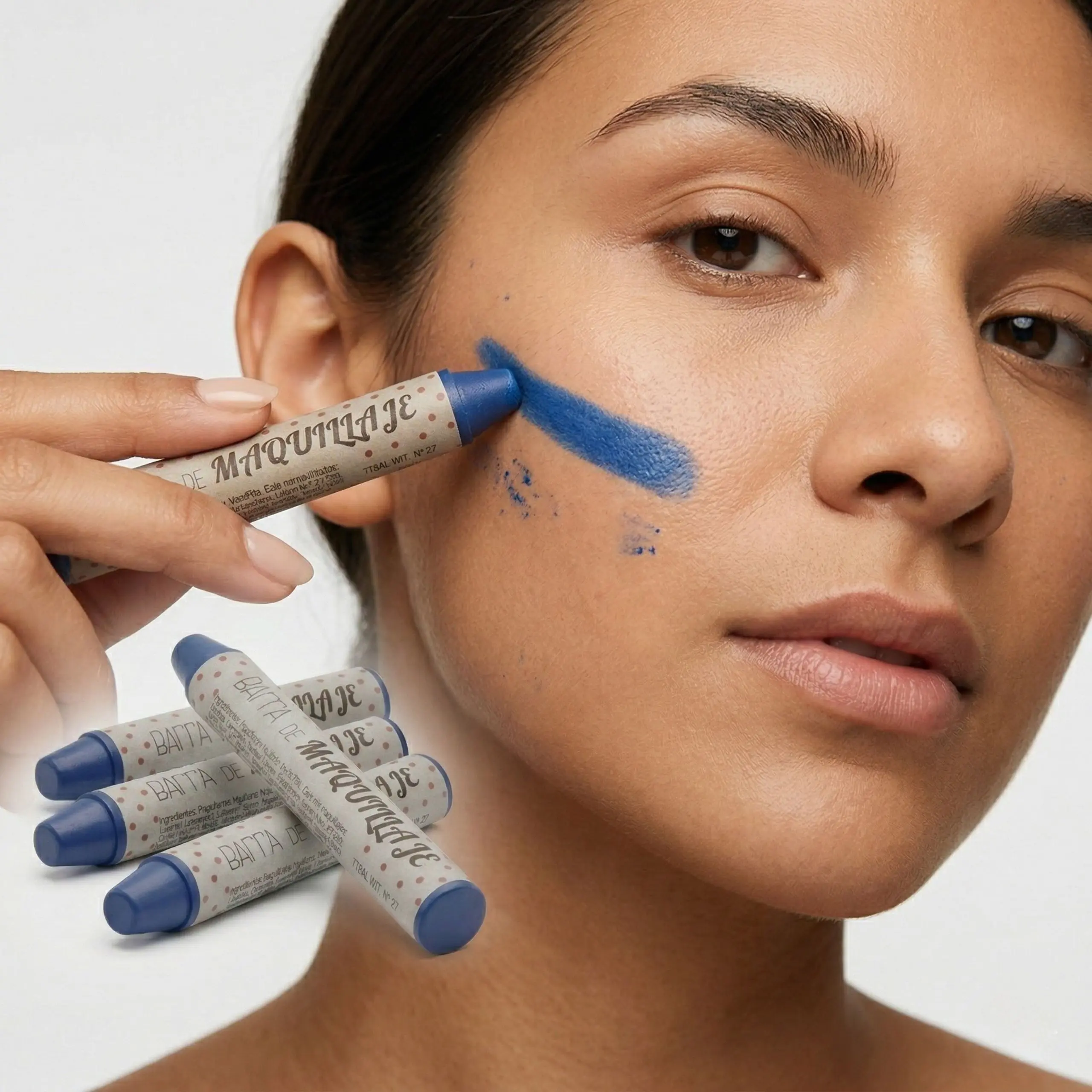 Primer plano de trazo vibrante de pintura facial azul en la mejilla mostrando la alta cobertura y acabado profesional.